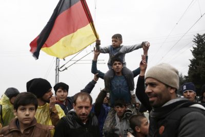 Migranti v Grčiji z Nemško zastavo jasno sporočajo, kam so namenjeni (foto: epa)