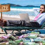Barefoot,Businessman,Working,On,His,Laptop,On,A,Beach,Chair