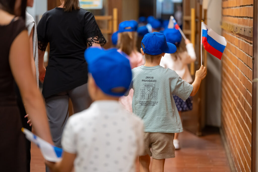 [Video] Prvošolci vkorakali v novo šolsko leto s slovenskimi zastavami in ustavo – to jim sporočajo naši politiki